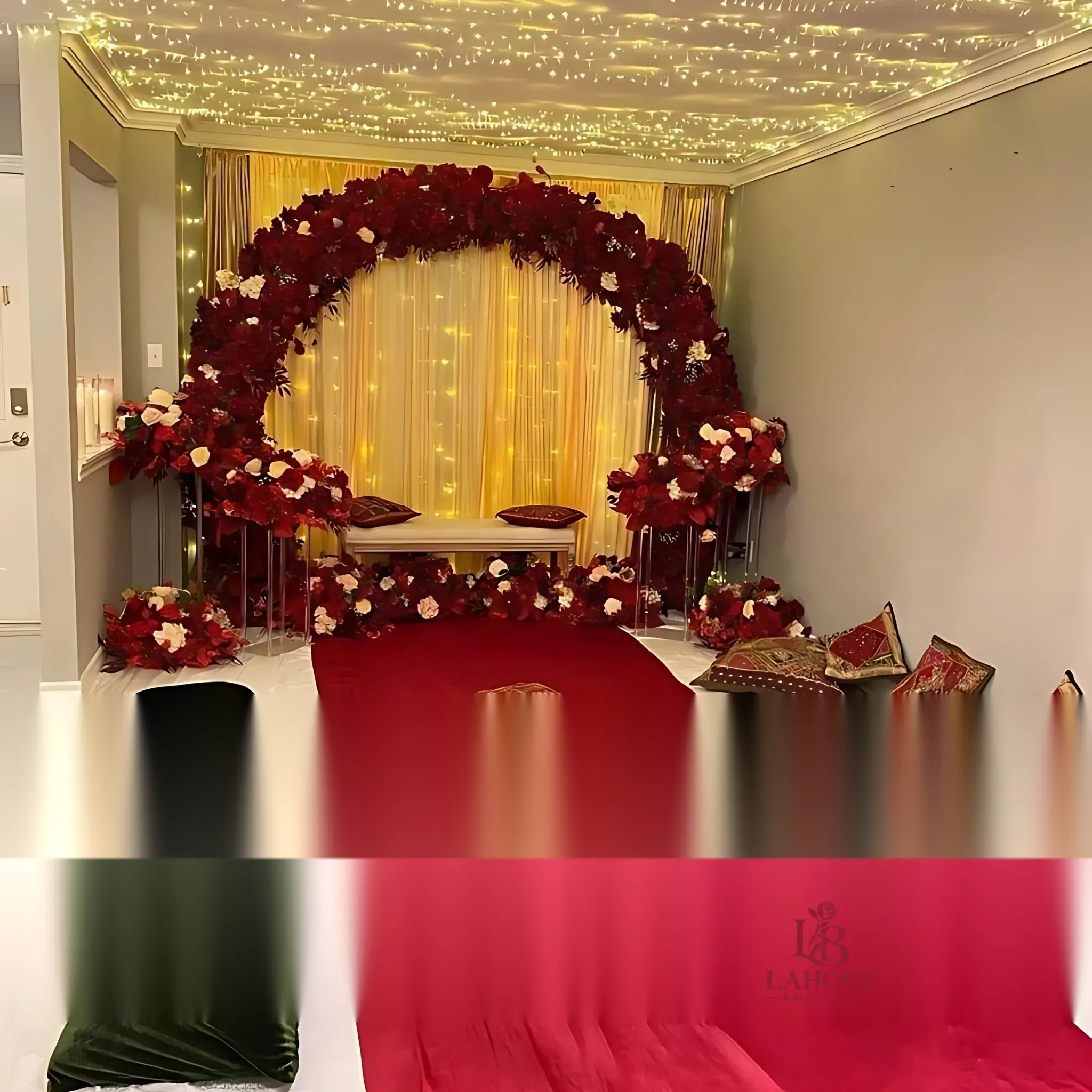 Luxurious Indoor Mehndi Setup with Red Floral Arch